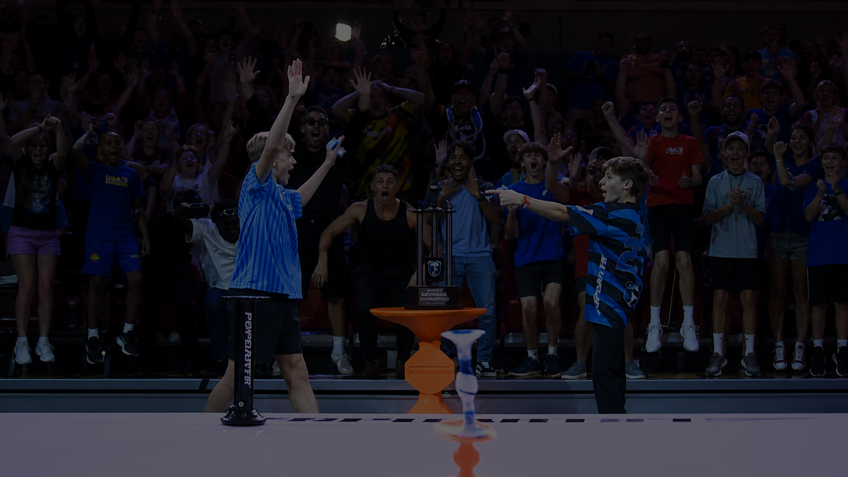 A player celebrating with a Popdart raised over a cheering APL Championship crowd.